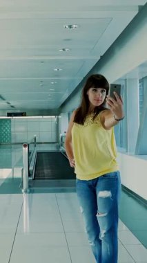 Genç ve güzel esmer kız olun selfie, crossing, akıllı telefon kullanarak metroda