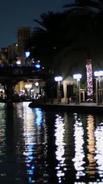 DUBAI, BİRLİK ARAB EMIRATES, BAE - 10 Mayıs 2017: Hotel Jumeirah Al Qasr Madinat, su kanalı boyunca gece yürüyüşü, bir tekne. Fenerler binaları aydınlatıyor..