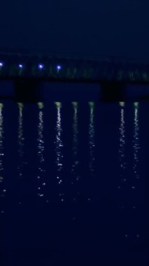 İyi geceler, suda köprü ve onun ışıklar yansıtılır. Uzun bir köprü Nehri.
