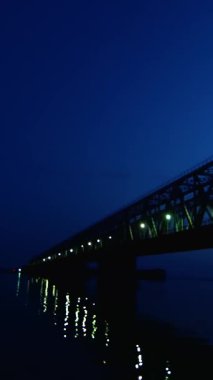 İyi geceler, suda köprü ve onun ışıklar yansıtılır. Uzun bir köprü Nehri.