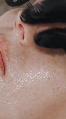 Güzellik terapisi. Yüz masajı. Kozmetik cilt bakımı. Yakın plan. Kadın güzellik kliniğinde yüz masajı, tonlu kaslar ve yüz lenfatik drenajı yaptırıyor. Yaşlanma karşıtı prosedür. Kadınlar için kozmetik prosedürleri.