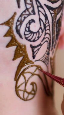 Yakın çekim, yürütme bir usta, bir sanatçı Mehdi, dövme, resmini kına Beyaz Cilt derisi üzerinde kel bir beyaz adam. Siyah, koyu kahverengi soyut süsler