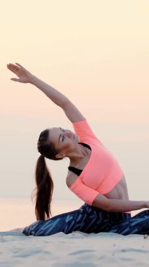 Gevşeme yoga poz deniz sahilde oturan kadın. gün doğarken. Rahatlatır kaslar, zihin, ruh ve beden uyumu satın aldı