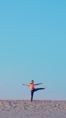 Sağlıklı, genç güzel kadın meditasyon, germe, pratik yoga deniz plajda güneş doğarken, denge ve koordinasyon, derin Kas tonusu için egzersizler yapar