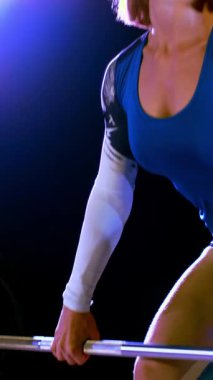 atletik genç kadın, halter yükseltir, halter ile mekik yok. Geceleri, hangarda bir eski terk edilmiş, Bina hafif duman, siste çok renkli projektörler ışığında