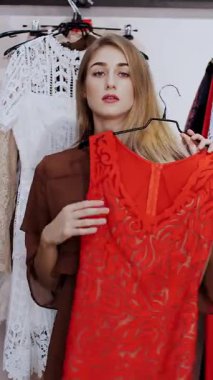 İş kadını mağazadan kıyafet seçer, aynanın karşısında kendine hayran kalır, gülümser. Şık bir giyim mağazasından alışveriş yapmak. yavaş çekim