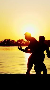 İki siyah erkek figürü, gün doğumunda, ışığa karşı, boks, dövüş, yaz aylarında, su kenarında, bir çift grev teknikleri eğitimi.