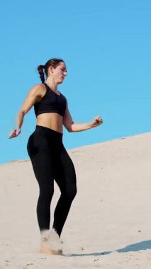 Siyah fitness takım elbiseli iki atletik, genç kadın bir çift içinde nişanlandık, başladı işe, ıssız plajda, mavi gökyüzü karşı yaz, sıcak güneşin altında dövüşmek tren. Ağır çekim