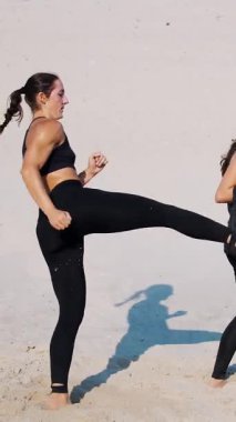 İki atletik, siyah takım elbiseli genç kadın, bir çift olarak nişanlanırlar, tekmeler, tren, çömelme ve tekmeler atarlar, çölde, sıcak bir güneşin altında,.