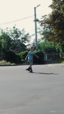 Mutlu çocuk, yedi, paten, sıcak bir yaz günü, iki erkek. Ağır çekim.