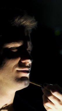 Cadılar Bayramı partisi, yakın çekim, makyaj sanatçısı bir Cadılar Bayramı partisi için bir adam yüzünde korkunç bir makyaj çizer.