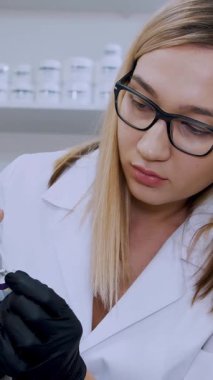 Doktor, hyaluronik asit enjekte etmeden önce hastanın dudaklarına anestezi uyguluyor. Hastanın dudaklarına anestezi merhemi sürdüm. Klinikteki kozmetoloji odası..