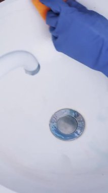 Lavaboya, temizlik mor koruyucu eldiven yakın çekim, kadın elinde kirli lavabo temizleyici ve sünger, bez ile yuvarlak seramik yıkayın. Ev kavramı