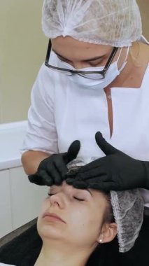 Yaşlanma karşıtı kozmetoloji. Yüz masajı. Kadın yüz masajı yaptırıyor. Güzellik kliniğinde kasları ve yüz derisini yumuşattığı için lenfatik drenaj yaptırıyor. Cilt bakımı, kadınlar için kozmetik prosedürleri.