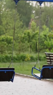 Boş salıncak yağmurda, rüzgarda sallanan drenches. şiddetli bir yağmur, bir fırtına, güçlü bir rüzgar ile şiddetli bir yağmur. Yağmurlu gün boyunca yağmur kaplı Bahçesi üzerine salıncak.