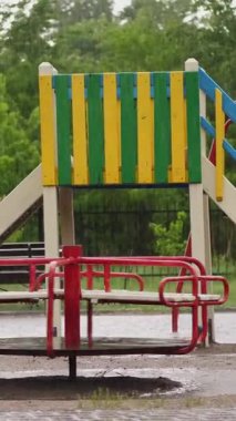 ağır yağmur, güçlü bir rüzgar ile şiddetli bir yağmur altında boş bir oyun alanı. büyük su birikintileri, yaz yağmurlu bir gün