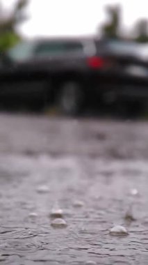 Yağmur, su birikintileri. Otoparka yağmur yağıyor. Yakın plan. Yağmur damlaları yağmur fırtınası sırasında su birikintilerine ve kabarcıklara düşer. yaz yağmurları.