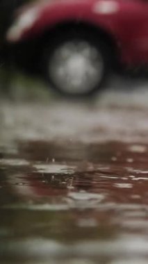 Yağmur, su birikintileri. Otoparka yağmur yağıyor. Yakın plan. Yağmur damlaları yağmur fırtınası sırasında su birikintilerine ve kabarcıklara düşer. yaz yağmurları.