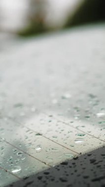 Arabadaki yağmur damlaları. Yağmur. Yağmur yağıyor. Yağmur damlaları beyaz arabanın arka camına düşer ve yağmur yağarken yavaşça damlar. yakın plan