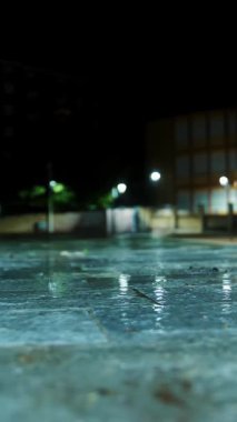 Yağmur. Su birikintisi. Geceleri şehir. Sokak ışıklarıyla yağmur damlası. Yakın plan..