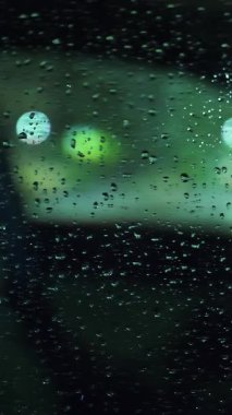 Yağmur damlalarında araba camı. Şehirde yağmur yağıyor. Sualtı yolu. İyi geceler. Yağmur damlaları. Yakın plan..