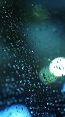 Yağmur damlalarında araba camı. Şehirde yağmur yağıyor. Sualtı yolu. İyi geceler. Yağmur damlaları. Yakın plan..