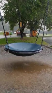 Çocuk parkında yağmurlu bir gün, Su birikintileri sallanırken