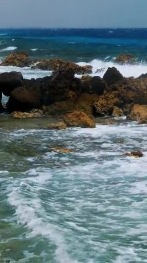 Güzel deniz manzarası. Beyaz köpüklü küçük sörf dalgaları Kızıl Deniz 'in kayalık sahillerinde kırılıyor. Yaz manzaralı deniz manzarası, güneşli sahil manzaralı..