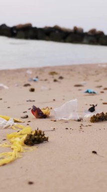 Yakın plan. Çöp, sahildeki çöp. Bir sürü plastik torba, kullanılmış plastik bardaklar ve koruyucu maskeler. Çevre kirliliği kavramı.
