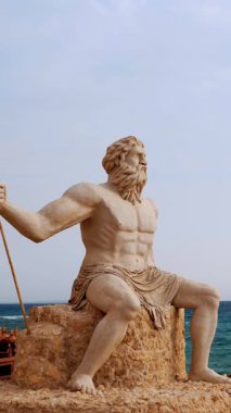 Sahilde Tanrı Poseidon 'un anıtsal heykeli, denizin arka planına karşı..