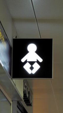 İşaretçi. Çocuklu yolcular için oda. Havaalanındaki işaret levhası. Bebek bezi simgesinde halka açık bir yerde işaretçi tahtasının üzerinde.