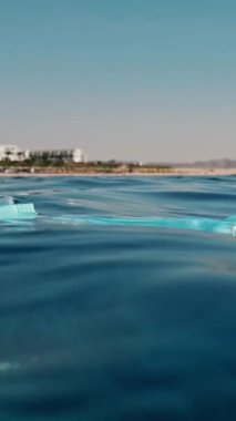 Denizde çöp. Denizi temizle. Denizde tıbbi maske. Sudaki çöpleri toplayın. Yakın plan. Erkek el atıkları yakalar, tıbbi maske kullanır. Birinci şahıs görüşü. Deniz ya da okyanus kirliliği. çevre koruması.