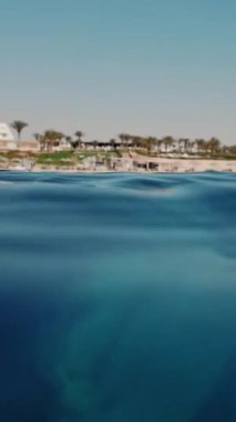 Denizde çöp. Denizde tıbbi maske. Tıbbi maskeler güneş ışığında yavaşça suyun altında sürükleniyorlar. Arka ışıklandırma. Çöp çevresi kirliliği sorunu