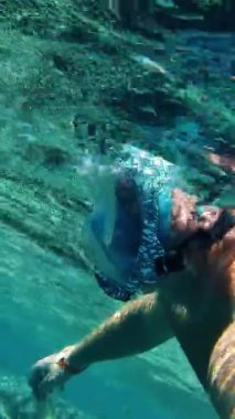 Şnorkelle yüzmek. Yüzme. Dalış. Şnorkel maskeli bir adam, sayısız renkli, egzotik resif balığıyla sualtı mercan resiflerini keşfediyor..