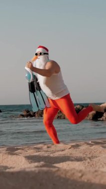 Noel Baba yaz tatili. Noel Baba eğleniyor. Güneş gözlüklü, yüzgeçli ve şnorkelli komik Noel Baba deniz sahilinde koşar. Yüzmek için acele ediyor, şnorkel..