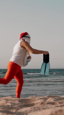 Noel Baba yaz tatili. Noel Baba eğleniyor. Güneş gözlüklü, yüzgeçli ve şnorkelli komik Noel Baba deniz sahilinde koşar. Yüzmek için acele ediyor, şnorkel..