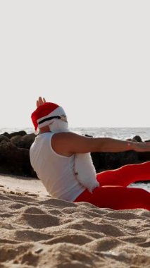 Noel Baba yaz tatili. Noel Baba eğleniyor. Komik Noel Baba, paletlerle, deniz kenarında kumlu sahilde uzanırken dinleniyor..