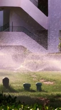 Çim sulama. Çim sulama sistemi. Çim fıskiyesi. Sulama sistemi. Su fıskiyeleri çalışıyor, bahçedeki çimenleri suluyor..