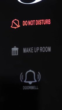 Rahatsız etmeyin. Yakın plan. İşaret kırmızı yanıyor. Elektronik plaka. Üzerinde yazı olan dijital bir kart. Rahatsız etmeyin, otel odasında..