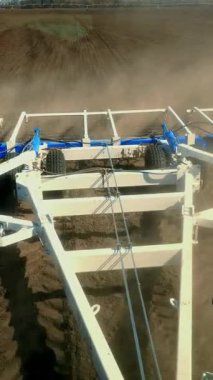 Çiftlik sahibinin taksisinden çiftliğin verimli arazisine. Traktör saban sürüyor, toprağı büyük metal sabanla donatıyor, tarıma elverişli topraklarda çok toz kaldırıyor, toprağı ekime hazırlıyor. Bahar ekini.