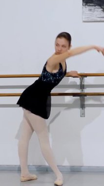 Dansçı stüdyodaki bale barında çalışırken zarif bir liman sütyen çalıştırıyor..