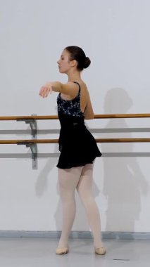 Dansçı, bar işi sırasında tekniklerine dikkat ederek bale pozisyonları sergiliyor..