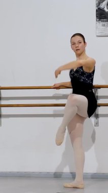 Barre egzersizi sırasında uygun arka hizayı ve biçimi gösteren balerin arka planı.