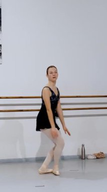 Yükselmiş kollu dansçı bale hareketi sahnesini denge ve kontrolle gerçekleştiriyor.