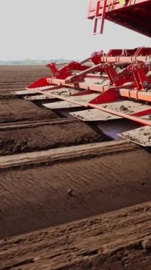 Yakın plan, çiftçi otomatikman tarladaki düz toprak sıralarına patates eker, daha iyi patates büyümesi için toprağa mineral gübresi ekler. Modern tarım. Bahar güneşli gün