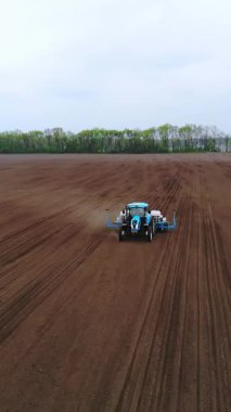 CHERKASY, UKRAINE, 28 NİSAN 2020: Aero, İHA videosu. Traktör bahar zamanı mısır tohumu ekiyor. Böcek ilacıyla tedavi edilmiş mısır ekiyorum. Döllenmiş toprağa mısır ekmek..