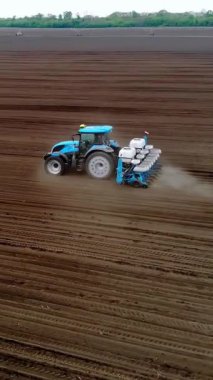 CHERKASY, UKRAINE, 28 NİSAN 2020: Aero, İHA videosu. Traktör bahar zamanı mısır tohumu ekiyor. Böcek ilacıyla tedavi edilmiş mısır ekiyorum. Döllenmiş toprağa mısır ekmek..