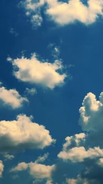 Zaman ayarlı. Mavi gökyüzünde, havadar, dönen bulutlar uçuyor. lşık güneşi parlıyor.