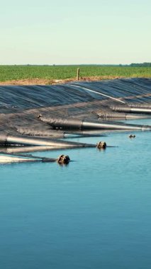 Borularla sulama deposu. İnsan yapımı, su depolama havuzu, tarımsal tarlalar için su tankı. Yakınlarda su almak için pompa istasyonu var. çiftçilik