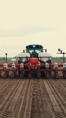 Özel hassas ekicileri olan traktör tarlada çalışıyor, mısır ekimi var, ya da ayçiçeği. Çiftlikte ekim mevsimi. Tarım alanında modern teknolojiler. Hava araştırması, bahar.